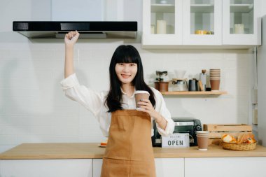 Başlangıçta başarılı bir küçük işletme sahibiydi. Kafede duran, elinde kahve tutan, el kol hareketi yapan bir kadın. 