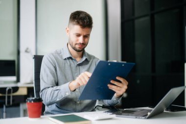 Genç yönetici ofiste çalışıyor.