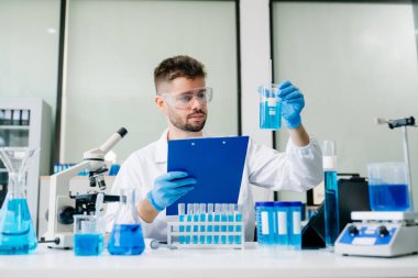 Erkek biyoteknoloji uzmanı yeni kimyasal maddeleri test ediyor. 