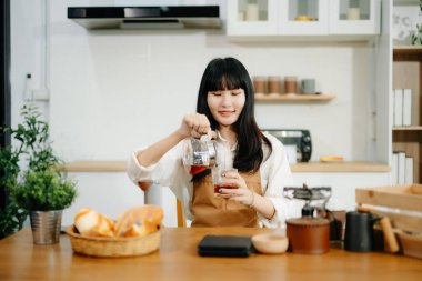 Profesyonel Asyalı kahve ustası taze espresso yapıyor. Evde ya da kafede yüksek kalite fasulyelerle rahat ve modaya uygun bir kafe deneyimi yaşayın.