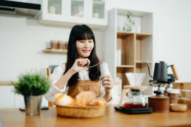 Profesyonel Asyalı kahve ustası taze espresso yapıyor. Evde ya da kafede yüksek kalite fasulyelerle rahat ve modaya uygun bir kafe deneyimi yaşayın.