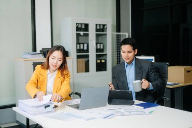 Nazik yönetici yönetici, Asyalı erkek pazarlama yöneticisiyle birlikte modern ofiste iş çözümlerini paylaşır ve tartışır.