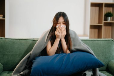 Genç Asyalı kadın grip belirtileri gösteriyor.