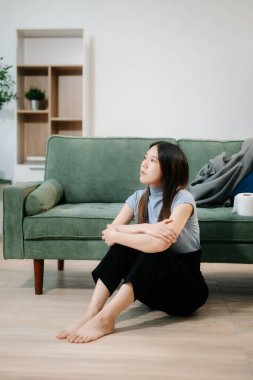 Asyalı kadın evde yerde yatıyor.