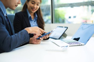 Sosyal ağ diyagramlı dizüstü bilgisayar ve tablet kullanan iş adamı ve masadaki verileri kavram olarak tartışan iki meslektaşı