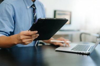 Akıllı telefon dizüstü bilgisayarı ve sosyal ağ diyagramı olan tablet kullanan bir iş adamı. Sabah ışığı konsepti olarak..