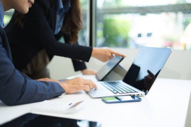 İş ekibi toplantısı. Finans müdürüyle çalışan profesyonel bir yatırımcı. Ofiste dijital tablet, akıllı telefon ve dizüstü bilgisayarla