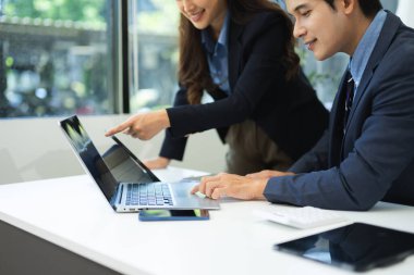 İş ekibi toplantısı. Finans müdürüyle çalışan profesyonel bir yatırımcı. Ofiste dijital tablet, akıllı telefon ve dizüstü bilgisayarla