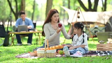 Aile yaz kampını kahve ve yiyecek kahvaltısıyla sever. Ebeveynler ve çocuklar piknik sırasında dışarıda kaynaşıyorlar. 