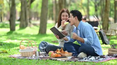 Aile yaz kampını kahve ve yiyecek kahvaltısıyla sever. Ebeveynler ve çocuklar piknik sırasında dışarıda birbirlerine bağlanıyorlar ve dijital tablet bilgisayar kullanıyorlar. 