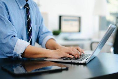 Ofiste akıllı telefon, tablet ve dizüstü bilgisayarda daktilo, daktilo yazan işadamı elleri.