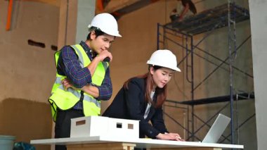 İki genç Asyalı mimar projeyi tartışıyor