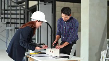 İki genç Asyalı mimar projeyi tartışıyor