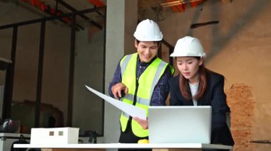 İki genç Asyalı mimar projeyi tartışıyor