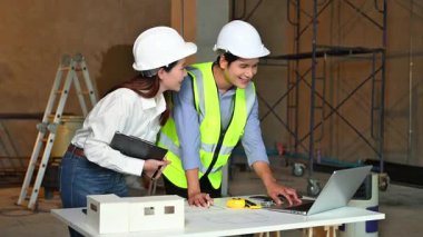 İki genç Asyalı mimar projeyi tartışıyor