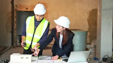 İki genç Asyalı mimar projeyi tartışıyor