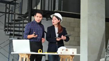 İki genç Asyalı mimar projeyi tartışıyor