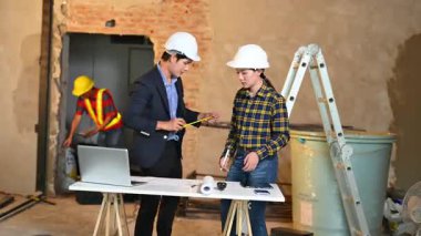 İki genç Asyalı mimar projeyi tartışıyor