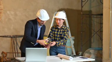 İki genç Asyalı mimar projeyi tartışıyor