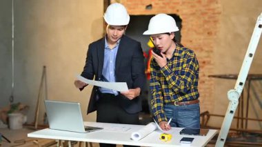 İki genç Asyalı mimar projeyi tartışıyor