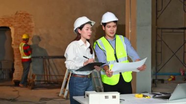 İki genç Asyalı mimar projeyi tartışıyor