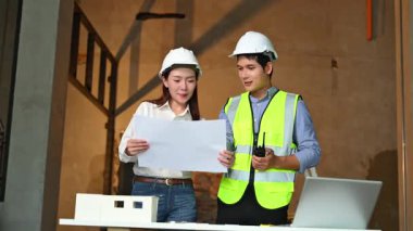 İki genç Asyalı mimar projeyi tartışıyor