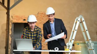 İki genç Asyalı mimar projeyi tartışıyor