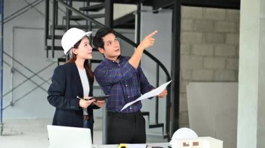 İki genç Asyalı mimar projeyi tartışıyor