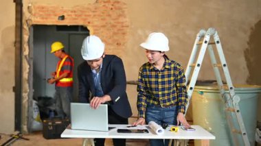 İki genç Asyalı mimar projeyi tartışıyor