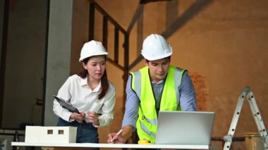 İki genç Asyalı mimar projeyi tartışıyor