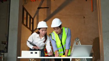 İki genç Asyalı mimar projeyi tartışıyor