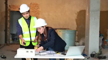 İki genç Asyalı mimar projeyi tartışıyor