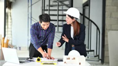 İki genç Asyalı mimar projeyi tartışıyor