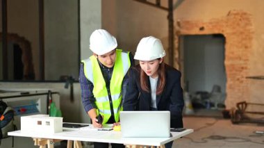 İki genç Asyalı mimar projeyi tartışıyor