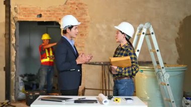 İki genç Asyalı mimar projeyi tartışıyor