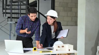 İki genç Asyalı mimar projeyi tartışıyor