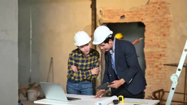 İki genç Asyalı mimar projeyi tartışıyor