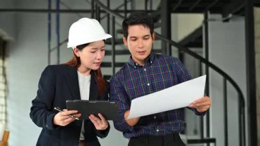 İki genç Asyalı mimar projeyi tartışıyor