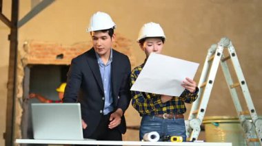 İki genç Asyalı mimar projeyi tartışıyor