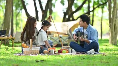 Mutlu genç Asyalı aile piknikte eğleniyor.