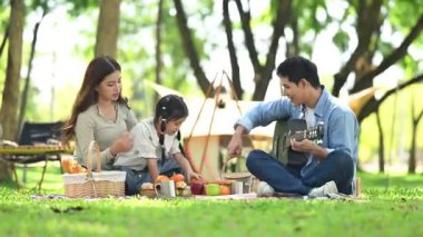 Mutlu genç Asyalı aile piknikte eğleniyor.
