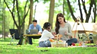 Mutlu genç Asyalı aile piknikte eğleniyor.