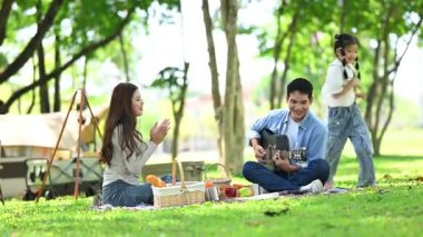 Mutlu genç Asyalı aile piknikte eğleniyor.