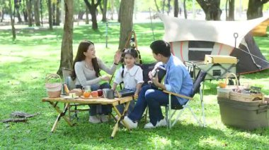 Mutlu genç Asyalı aile piknikte eğleniyor.