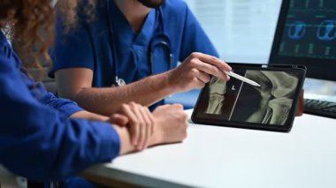 Doktorlar danışma sırasında tabletteki tıbbi görüntüleri tartışıyor