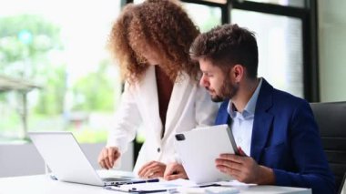 İşadamı ve iş kadını, dizüstü bilgisayar kullanarak ofiste iş birliği yapıyor. Stratejik takım çalışması ve anlayış şirketin büyümesini ve başarısını tetikliyor 