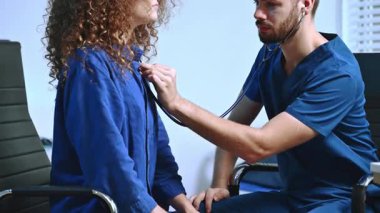 Klinikte steteskop kullanan hastayı muayene eden doktor.