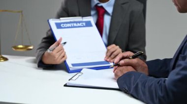 İş adamları ve avukatlar masada otururken sözleşme belgelerini tartışıyorlar. Hukuk kavramları, hukuki danışmanlık ve mesleki hukuk hizmetleri