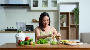 Modern mutfak ortamında taze sebze hazırlayan kadın.