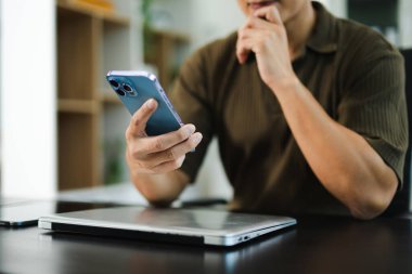 Bilgisayarda, tablette ve modern ofisindeki iş yerinde çalışan kendine güvenen iş adamı.